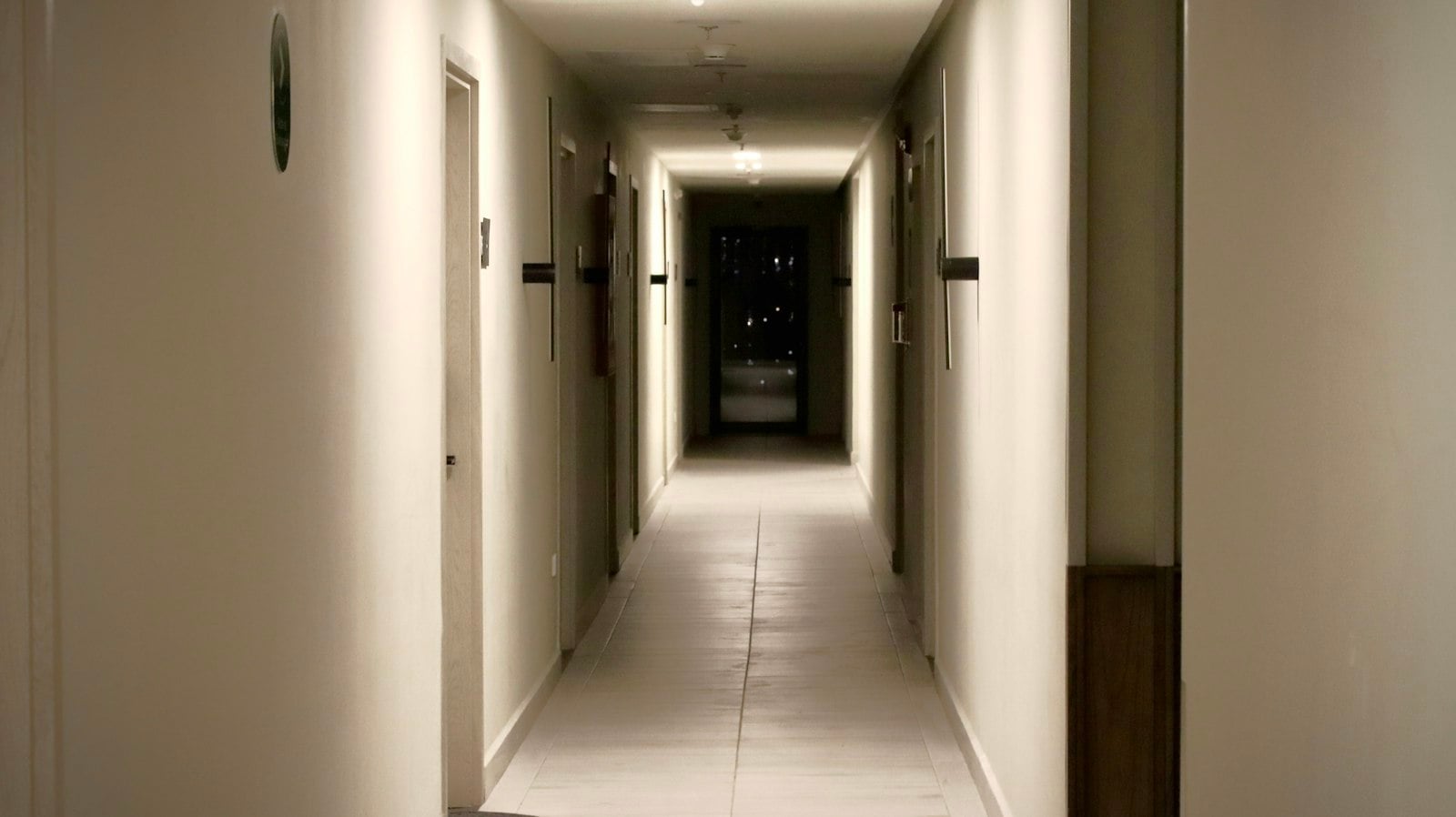 A long, dimly lit hallway with doors on both sides
