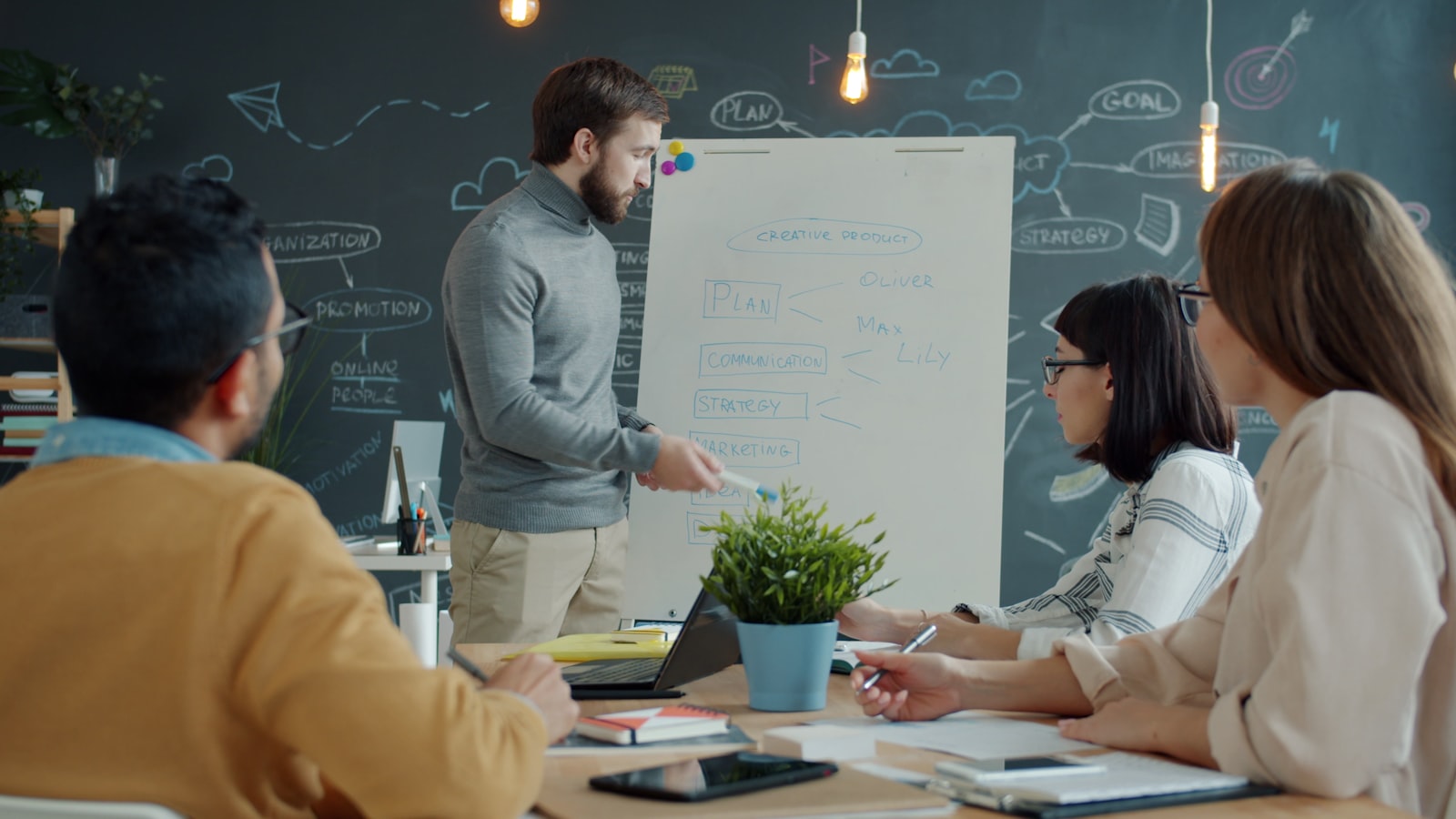 Marketing strategist presenting operational framework to colleagues at a whiteboard planning session